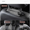 A black leather car seat with multiple storage hooks visible on the back and front.