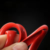 A hand is holding a red universal car rim protector strip, showing its curved shape and texture.