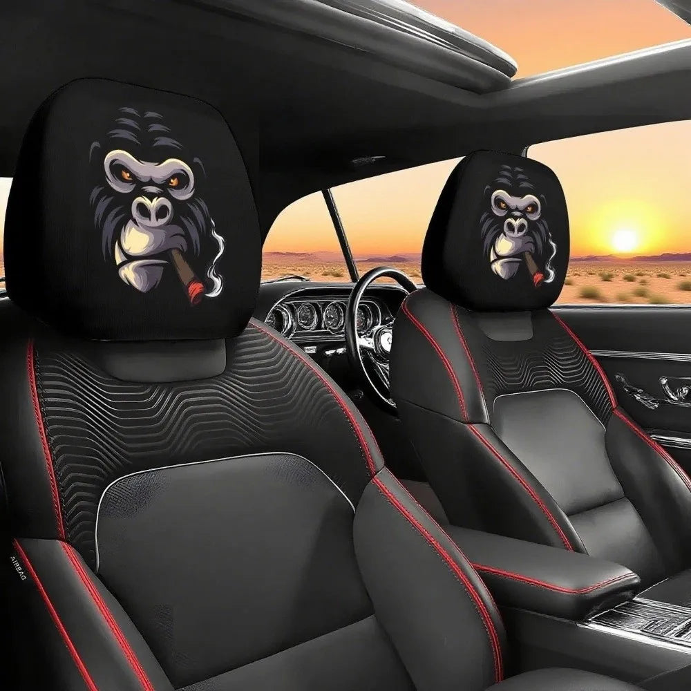 Black car seat headrest covers featuring decorative toucan or monkey patterns on a black leather interior.