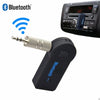 Adaptateur microphone Bluetooth noir avec connecteur, montré à côté d'une unité de radio automobile.