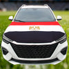 A white car hood decorated with a flag featuring red, white, and blue horizontal stripes and a gold emblem.