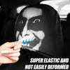 A hand is holding a black car seat headrest cover featuring a white face design with blue stripes.