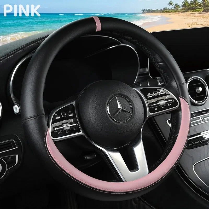 A black steering wheel with a pink leather trim is shown inside a car cockpit.
