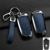 A dark blue aluminum alloy key fob cover with a metal split ring attached to a leather strap and a keyring.