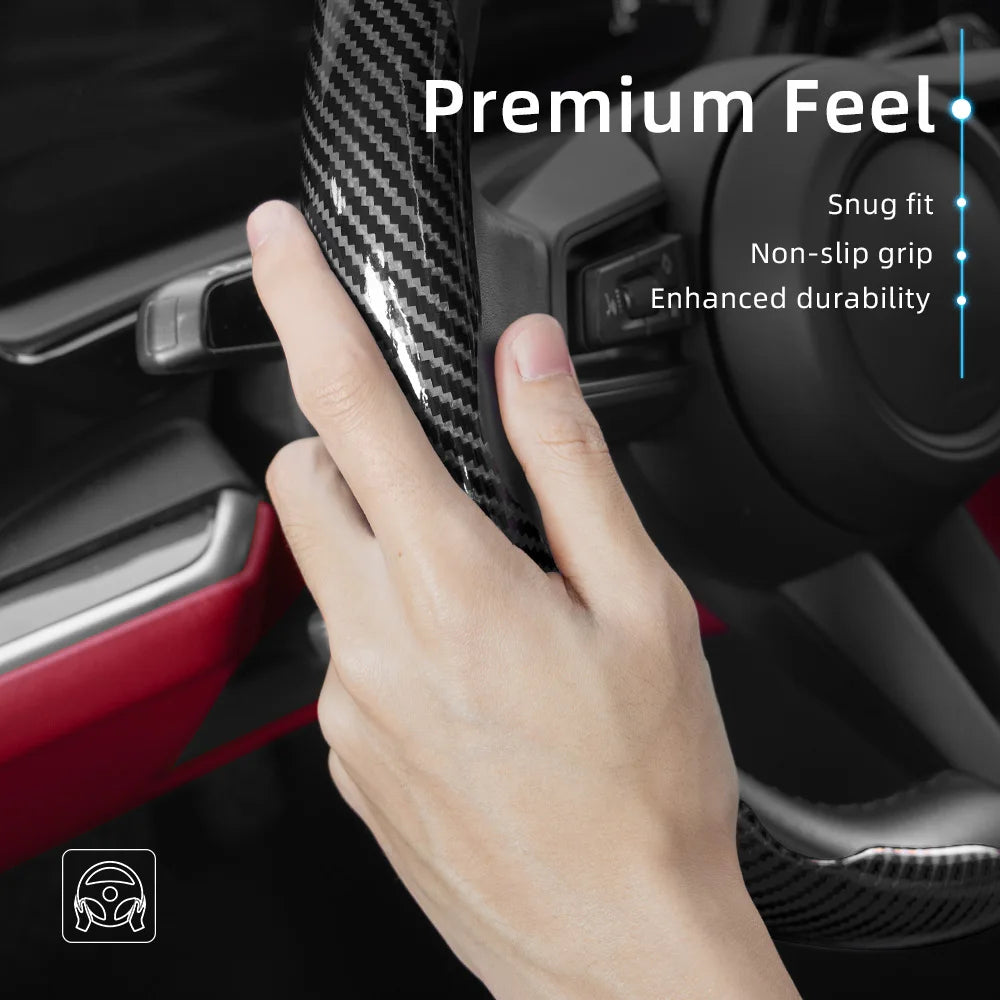 A hand is gripping a black carbon fiber steering wheel cover, highlighting its premium feel and durability.