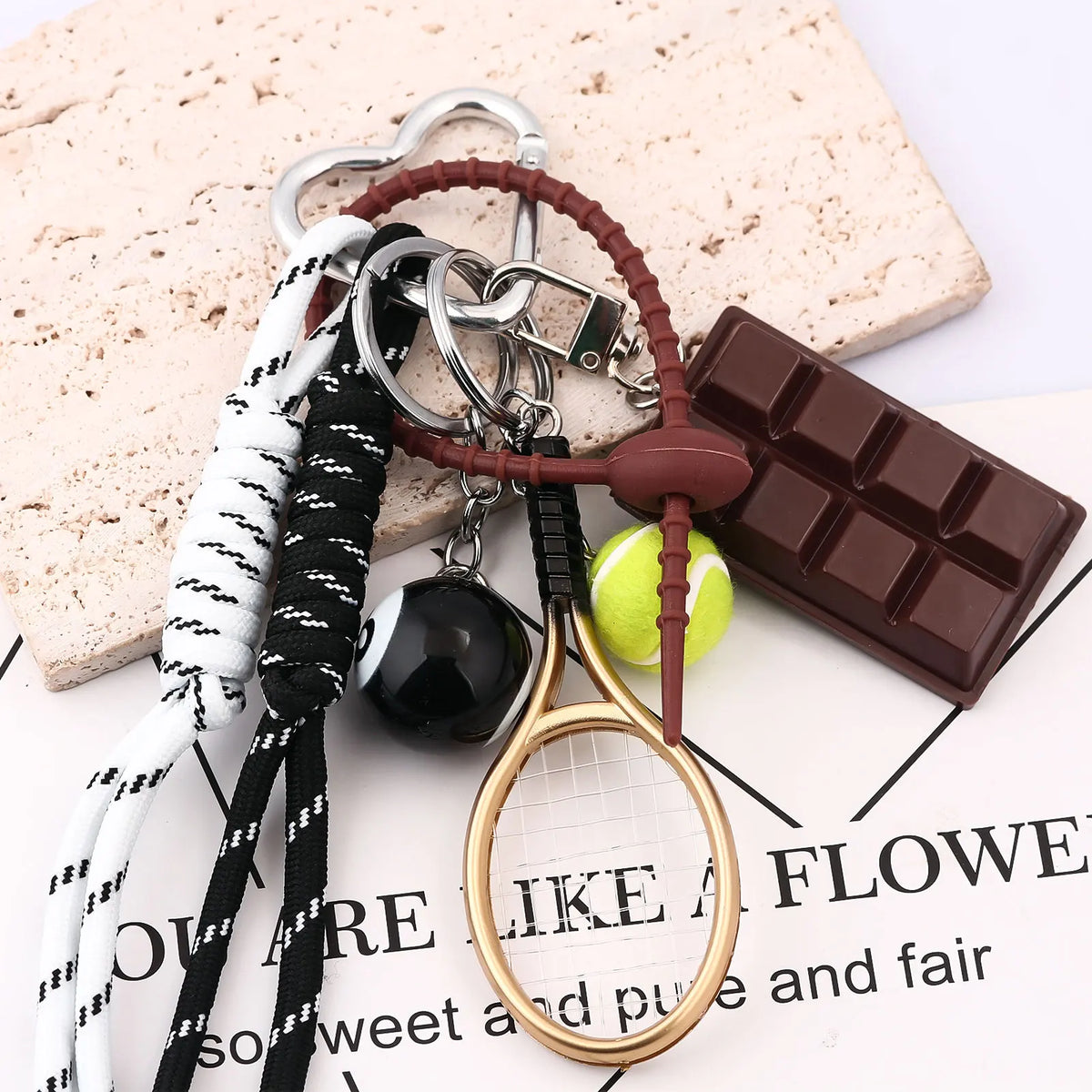 A set of sporty billiard bag charm keychains featuring leather and black cord with a gold-rimmed magnifying glass charm.