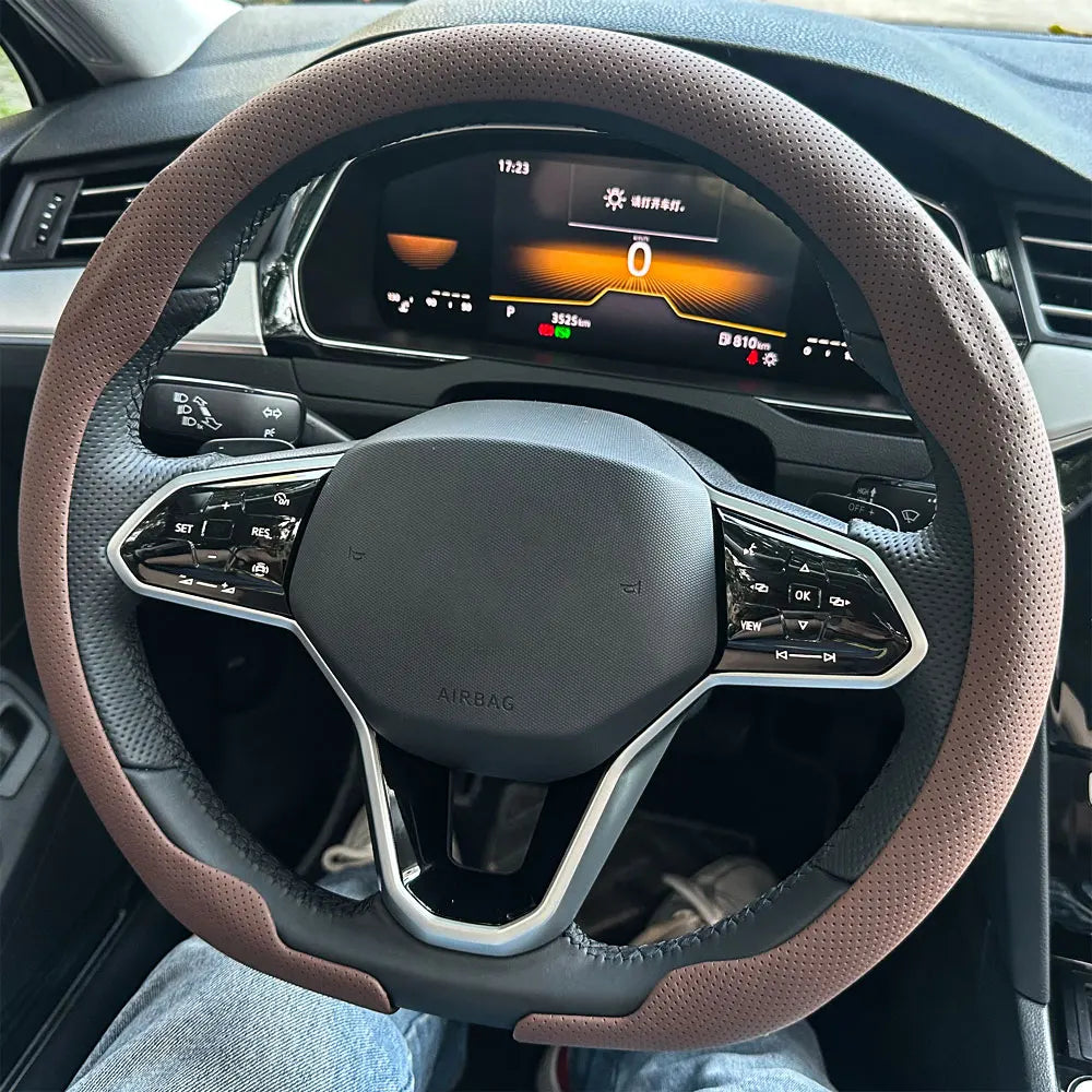 Nahaufnahme eines Lenkrads mit atmungsaktivem Lederüberzug, das Airbag und Bedienelemente zeigt.