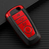 A red multi-function key fob holder with several buttons is shown on a dark surface.
