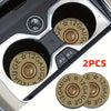 Two brass gauge bullet car cup mats are shown inside a silver car cup holder.