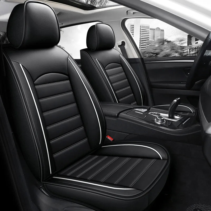 Interior view of a car showing black leather seat covers with stitching and headrests.