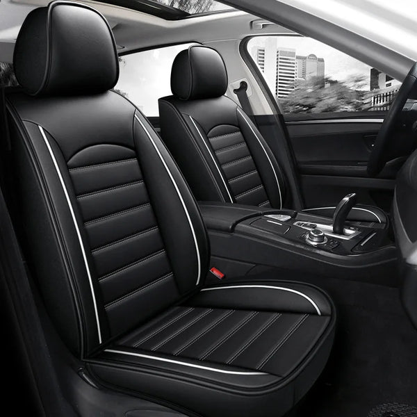 Interior view of a car showing black leather seat covers with stitching and headrests.