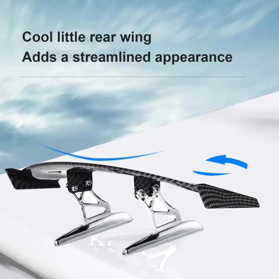 A carbon fiber rear wing is shown mounted on a white surface.
