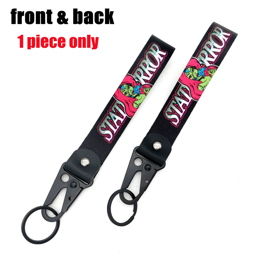 Vorder- und Rückansicht eines schwarzen Lanyards mit rosa und grünen Anime-Auto-Designs als Schlüsselanhänger.