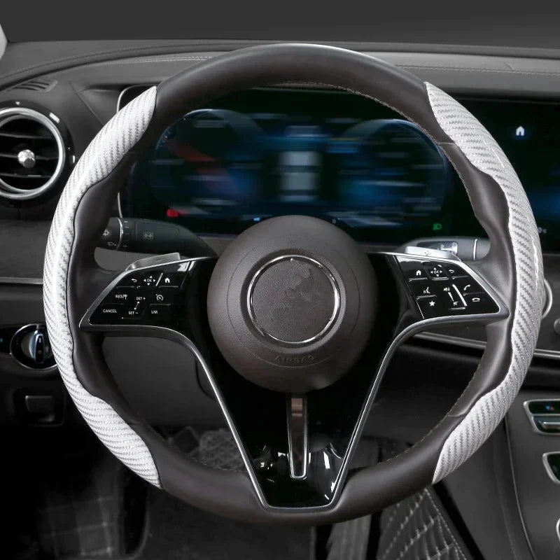 Nahaufnahme eines schwarzen Lenkrads mit einer weiß gemusterten Abdeckung im Autointerieur.
