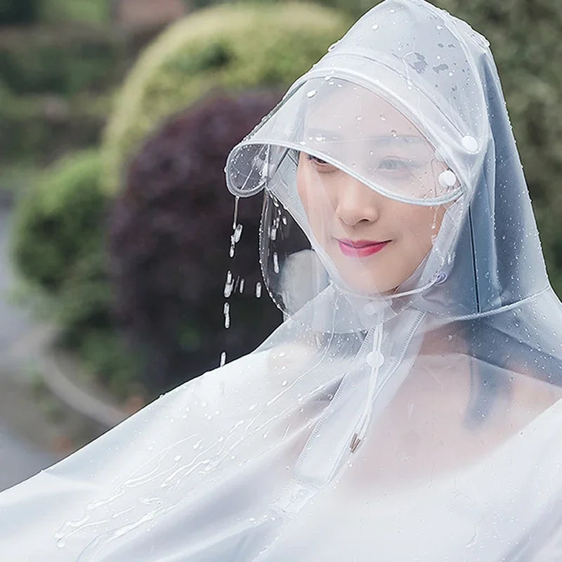 A woman wearing a transparent windproof motorcycle rain poncho with water droplets on her face and shoulders.