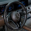 Nahaufnahme eines schwarzen Lederspeulers mit Laser-Carbonfaserabdeckung und Mercedes-Benz-Armaturenbrett.