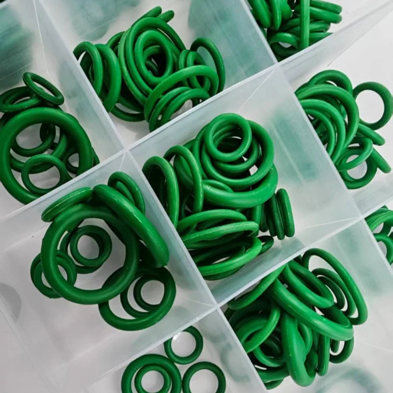 A collection of green rubber O-rings and gaskets are neatly arranged in a clear plastic compartment.