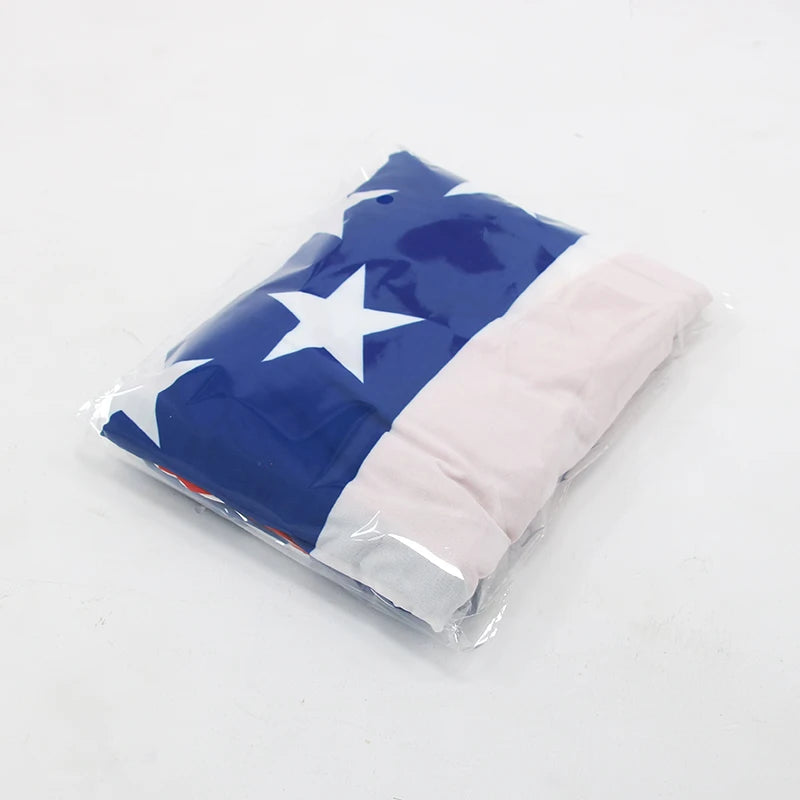 A navy blue and white patriotic windproof car hood cover is shown packaged in clear plastic.