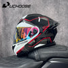 Un casque de moto modulaire noir et blanc DOT posé sur un siège en cuir noir.
