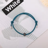 A blue braided fitness tracker bracelet is displayed on a white background next to a sign labeled White.
