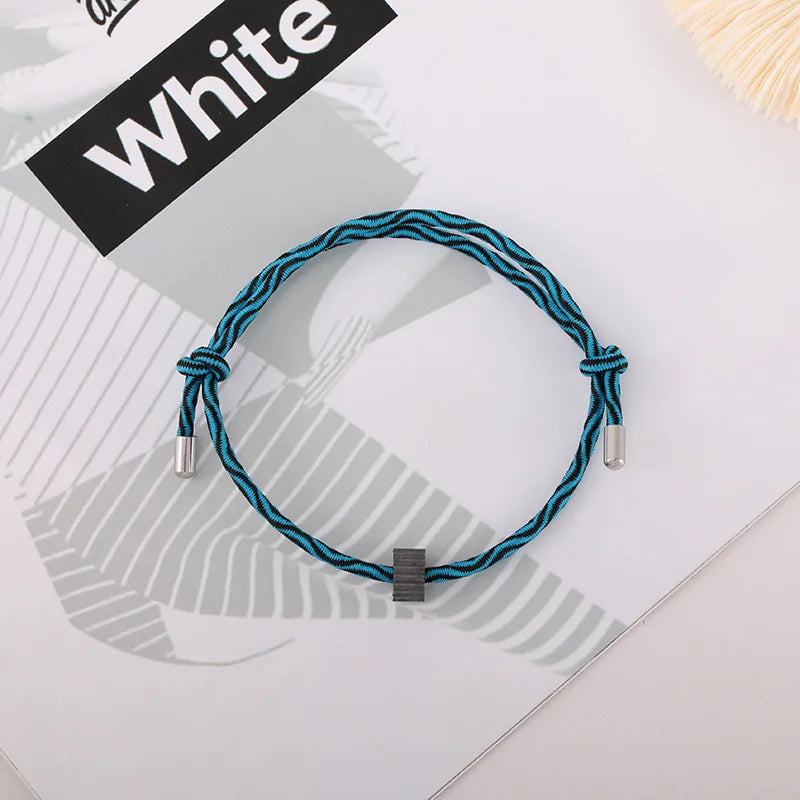 A blue braided fitness tracker bracelet is displayed on a white background next to a sign labeled White.