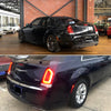 A black Chrysler 300 sedan with aftermarket rear bumper reflector light covers.