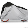 A gray and black all-weather bicycle cover is shown folded on a bicycle frame.
