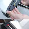 A hand holds a white and black sports rain deflector product designed for car side mirrors.