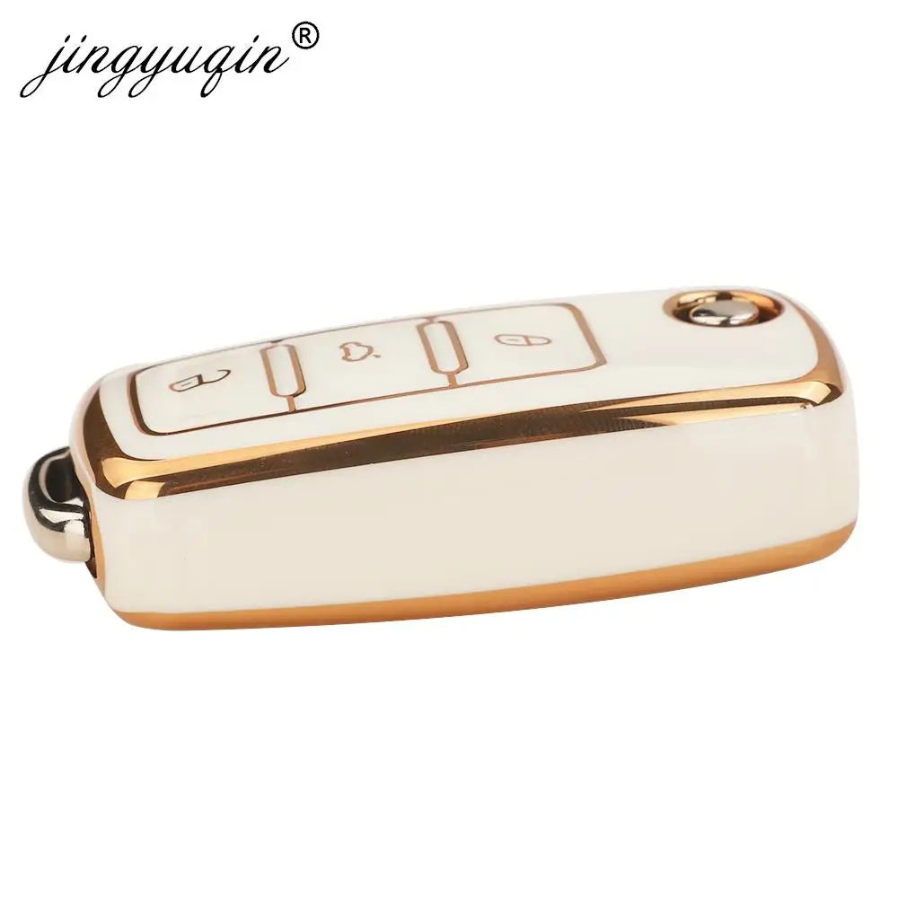 A white silicone TPU car key cover protector with gold accents and multiple buttons.