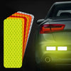 A set of yellow and orange high-visibility reflective safety strips displayed next to a dark car's taillight.