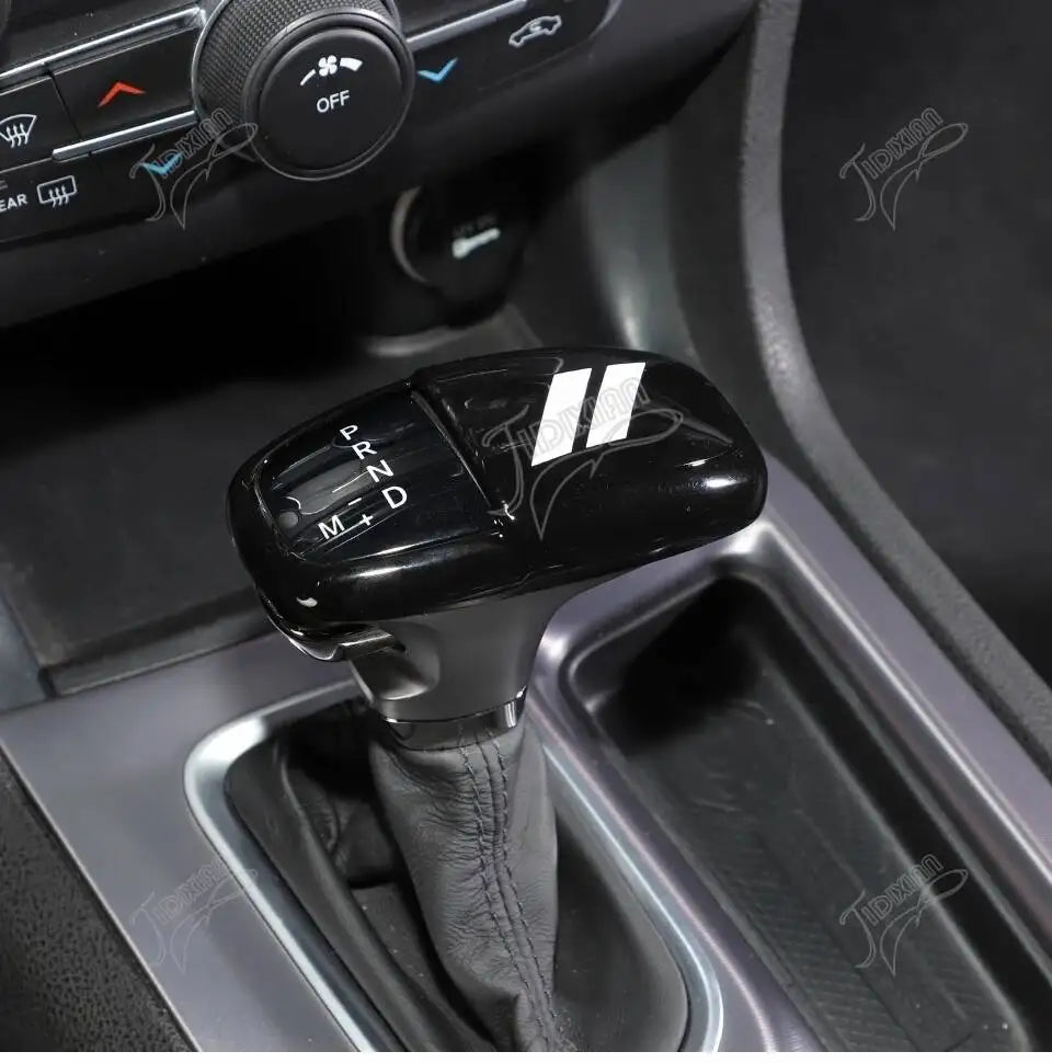 Nahaufnahme der Dekokappe für den Schaltgriff eines schwarzen Autos von Dodge.