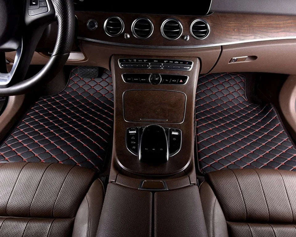 Interior view of a car showing leather seats, wood trim, and controls for floor mats.