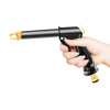 Eine Hand hält eine schwarze Hochdruck-Wasserpistole mit goldener Düse, bereit zum Reinigen.