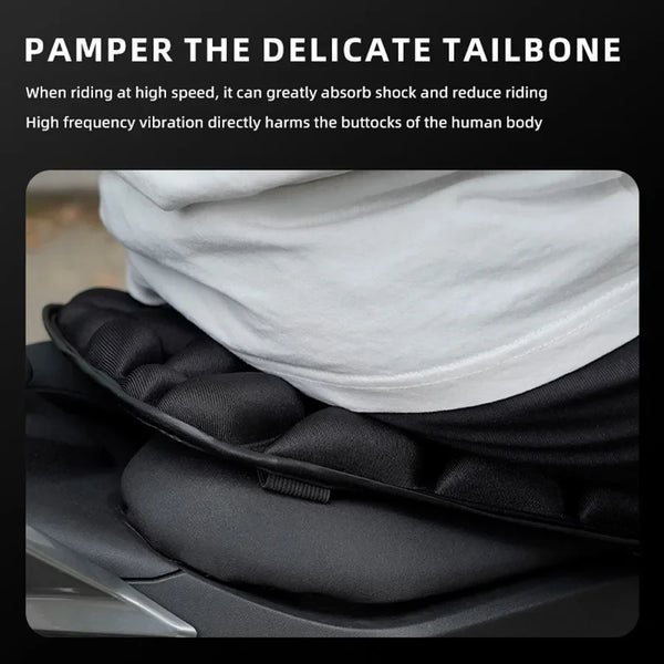 A black motorcycle seat pad is shown, designed to pamper the delicate tailbone.