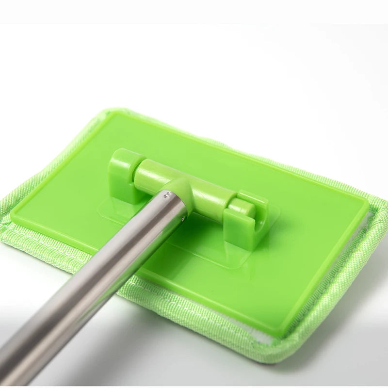A silver telescopic windshield cleaning brush is shown resting on a bright green microfiber cleaning cloth.