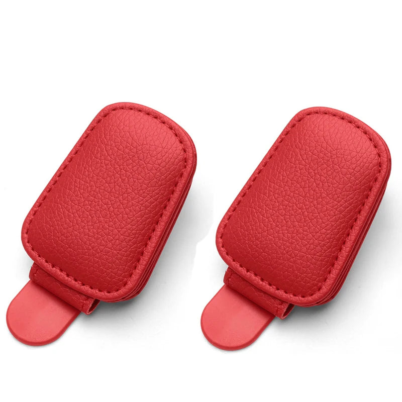 A pair of red magnetic leather sunglasses holders designed for car sun visors.