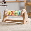 A wooden rainmaker musical toy featuring colorful, interlocking plastic raindrops displayed in a wooden frame.