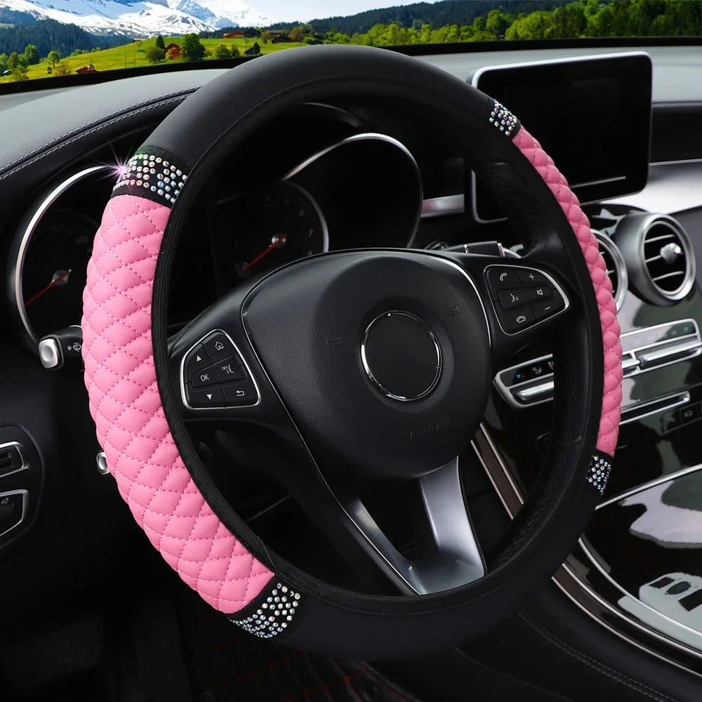 Close-up view of a black steering wheel with a pink embroidered leather cover in a car interior.
