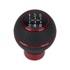 A black gear shift knob with a digital display showing numbers 1 through 5 and R, mounted on a red base.