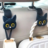 Black 3D cartoon cat headrest hooks used to secure storage items in a car