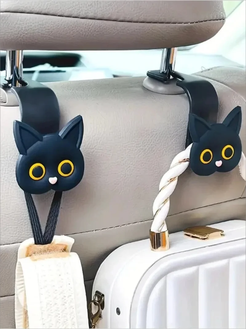 Black 3D cartoon cat headrest hooks used to secure storage items in a car