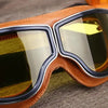 A pair of retro folding motorcycle windproof glasses with brown leather frames and amber tinted lenses.