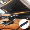 Une main ouvre un pare-soleil pliable de voiture à l'intérieur de l'habitacle.