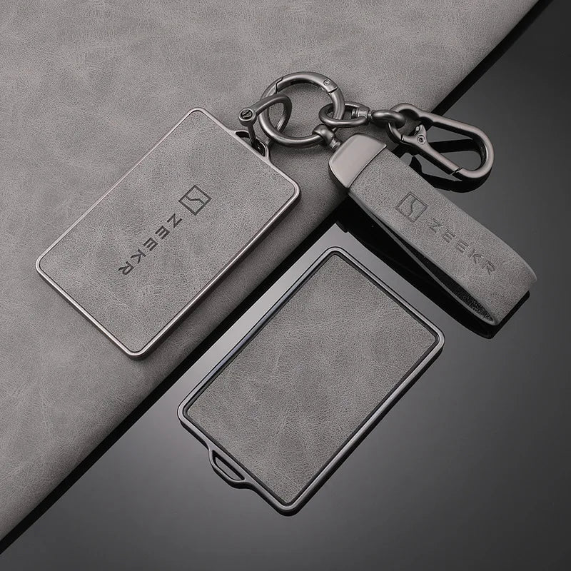 Gros plan d'un porte-clés NFC avec une clé métallique posée sur une surface en cuir gris.