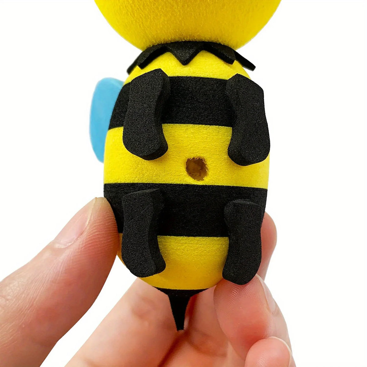 A yellow and black bee-shaped antenna decoration set being held in a hand.