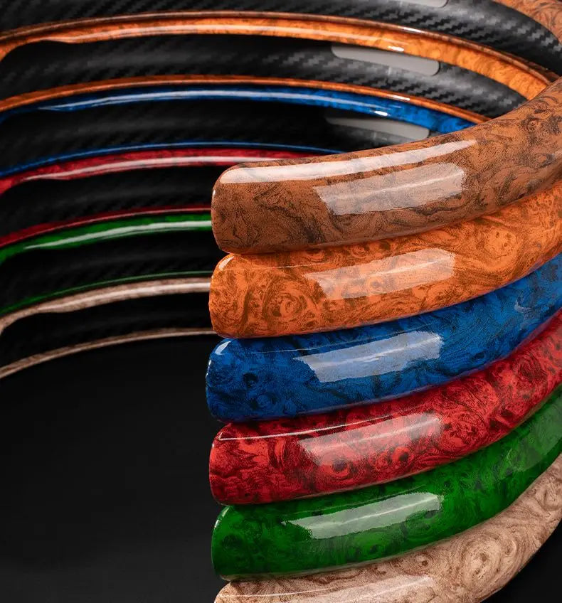 A close-up of various colored anti-slip steering wheel covers with peach wood grain finishes.