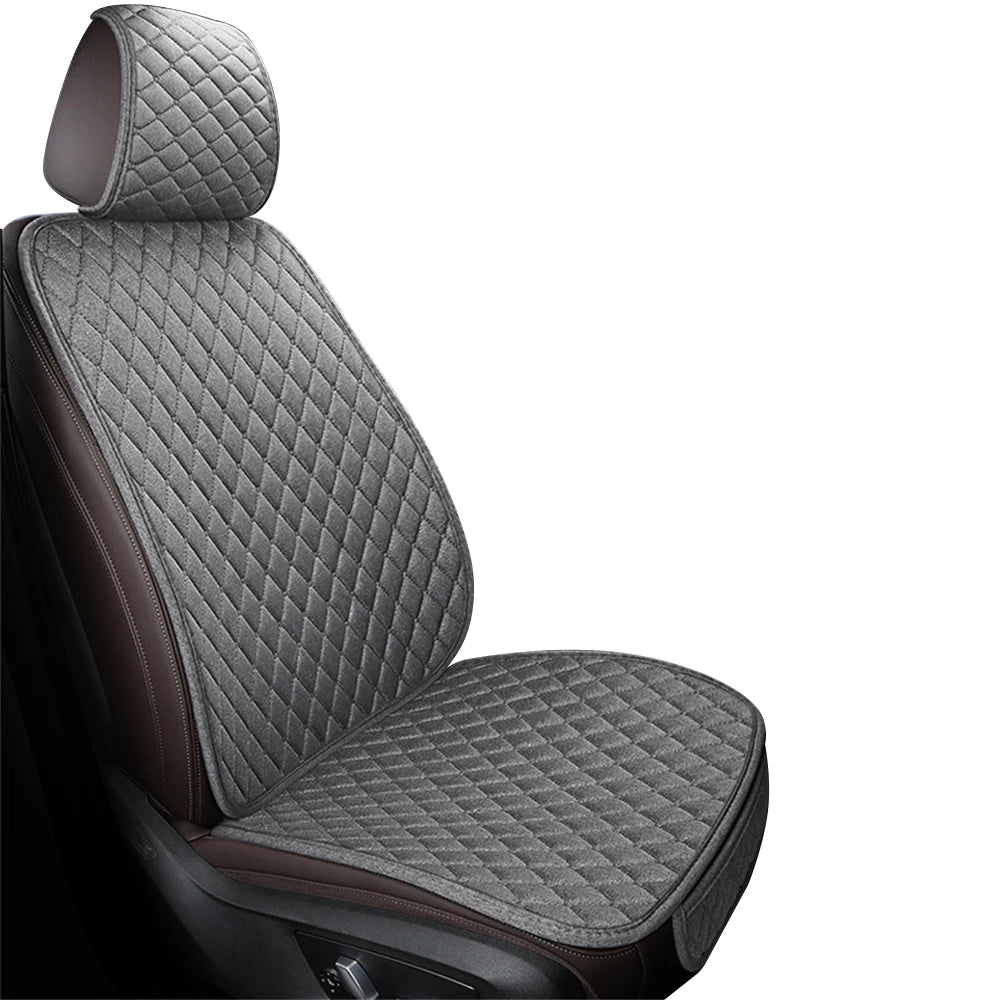 A close-up view of a dark gray quilted car seat and floor mat with brown accents.
