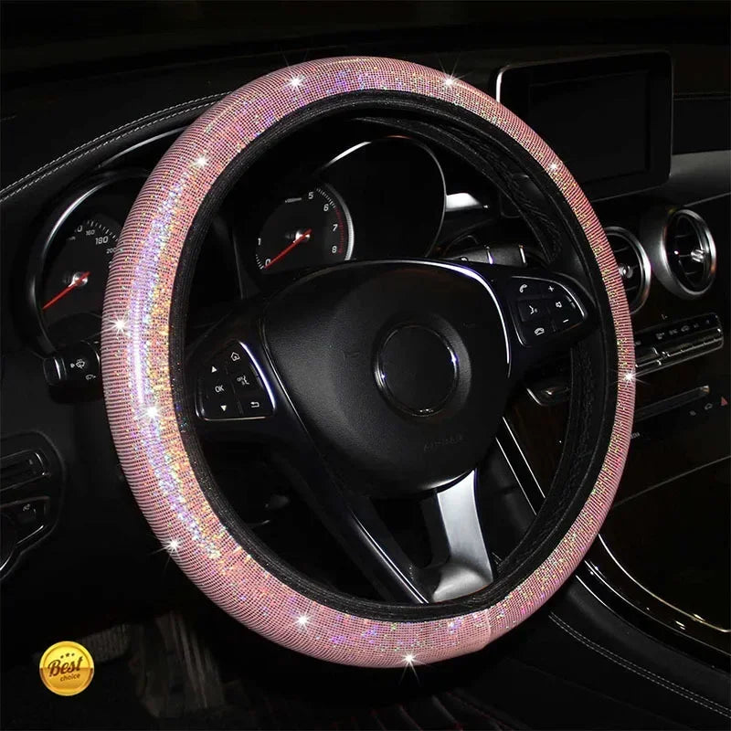 Nahaufnahme eines schwarzen Lenkrads, bedeckt mit funkelndem rosa Kristalldiamantmaterial.
