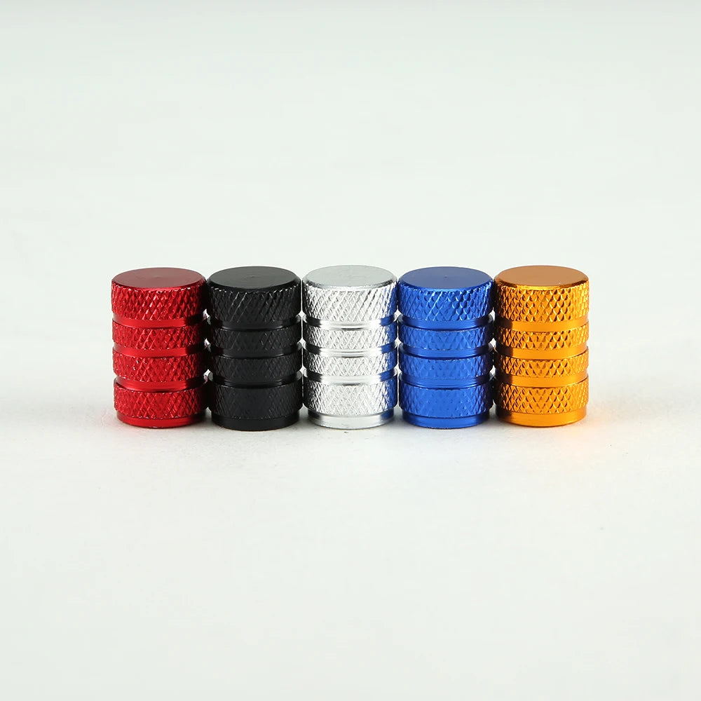 A set of eight aluminum tire valve caps in red, black, silver, blue, and orange stacked in a row.