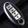 A silver car key fob cover with a textured black surface and multiple buttons.